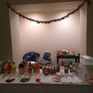 Table with various drinks and mocktail mixers, decorated with hearts and a red garland